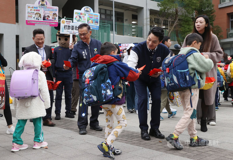 全國中小學16日正式開學，台北市長蔣萬安（右3）在北市教育局長湯志民（左3）陪同下，前往南港東新國小參加國小開學日活動，兩人一起在門口發放紅包。中央社記者鄭傑文攝  113年2月16日