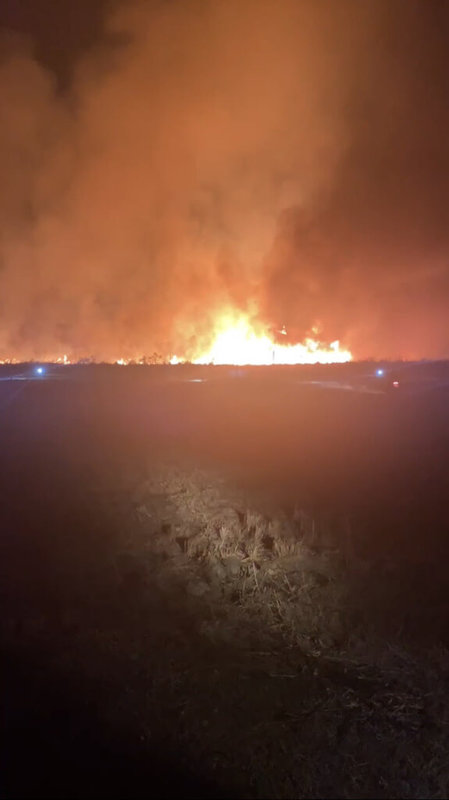 屏東縣潮州鎮內一處台糖農地16日晚間發生雜草火災，熊熊火光照亮黑夜，屏東縣消防局獲報派員到場搶救，約在晚間10時許撲滅火勢。（屏東縣消防局提供）中央社記者張已亷傳真 113年2月16日