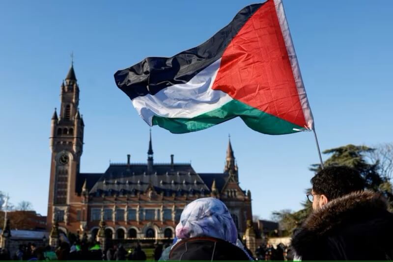 圖為1月26日在國際法院外民眾高舉巴勒斯坦國旗。（路透社）