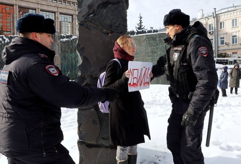 圖為17日一名女子在納瓦尼的紀念集會中舉著「謀殺」標語，遭俄羅斯警方逮捕。（路透社）