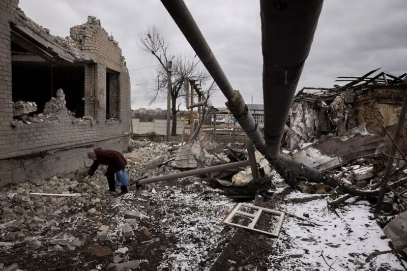圖為19日烏克蘭東部市鎮塞利多韋的居民正在清理受攻擊的家園。（路透社）