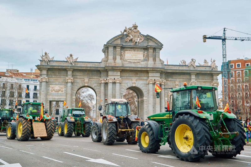 西班牙各地農民駕駛耕耘機進入首都馬德里，在阿爾卡拉門（Puerta de Alcalá）紀念碑集合，抗議歐盟嚴厲的環保法規與放任不公平競爭作為，導致生存困難。中央社記者胡家綺馬德里攝  113年2月22日