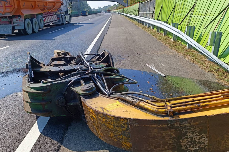 1輛挖土機23日在國道3號台南關廟路段邊坡進行工程意外翻覆,挖土機部分伸展臂倒在路肩,警方一度封閉外側車道及路肩進行處理。(讀者提供)中央社記者楊思瑞台南傳真 113年2月23日