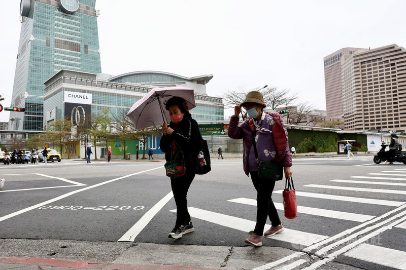 中央氣象署表示,23日大陸冷氣團影響,北台灣低溫攝氏13至15度、高溫15至18度,整天感受偏冷,迎風面的基隆北海岸、東半部地區及恆春半島有局部短暫雨,桃園以北地區降雨較零星,新竹以南地區維持多雲到晴的天氣。圖為台北市信義區民眾撐傘過馬路。中央社記者翁睿坤攝 113年2月23日