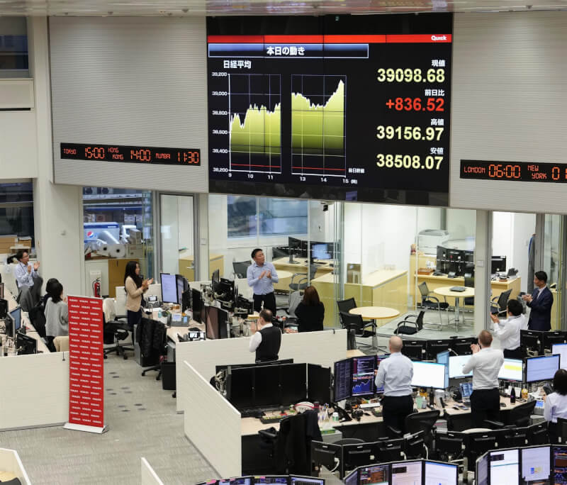 日本股市日經指數22日創下收盤新高，證券公司人員收盤後起身鼓掌。（共同社）