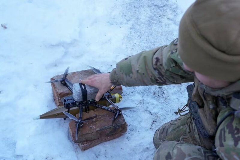 圖為一名烏克蘭軍人放置裝有榴彈發射器的無人機。（路透社）