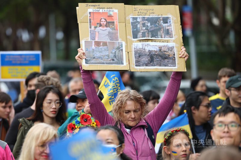 俄羅斯入侵烏克蘭滿2週年，民間團體「台灣烏克蘭陣線」24日在台北大安森林公園發起遊行活動，有參與民眾手舉看板，透過照片呈現戰火無情。中央社記者王騰毅攝 113年2月24日