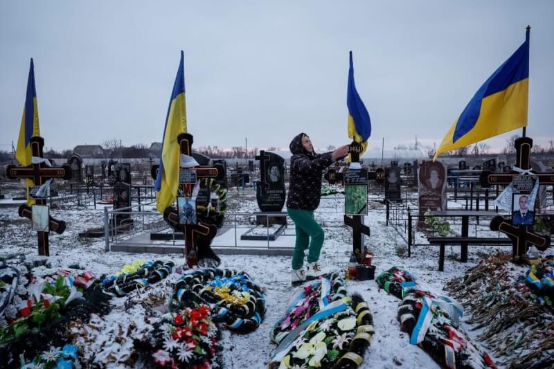 圖為烏克蘭民眾在公墓的英雄巷為丈夫掃墓。（路透社）