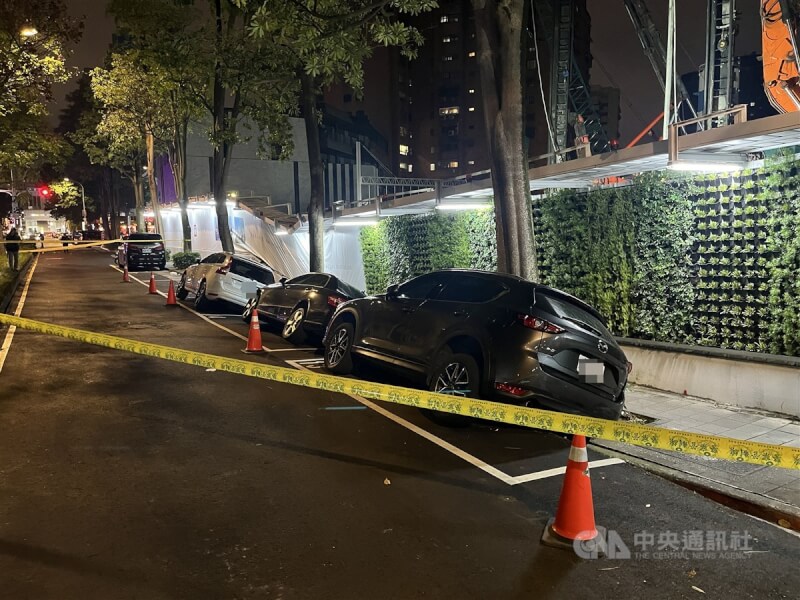 台北市松山區慶城街附近一處新建工地23日晚間驚傳地層下陷,有停放在工地旁停車格內汽車遭波及,車身明顯傾斜,警方已在場拉起封鎖線,建管處獲報也已派員到場。中央社記者徐肇昌攝 113年2月23日
