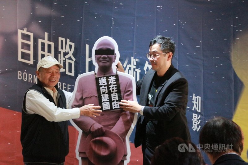 好民文化行動協會等單位舉辦的「自由路上藝術節」25日在台中開幕,會中豎立蒙眼的前總統蔣介石人型看板,由好民文化行動協會理事長鍾瀚樞(右)及台中市新文化協會理事長陳彥斌(左)掛上「走在自由,邁向建國」標語牌,表達移除過的威權。中央社記者蘇木春攝 113年2月25日
