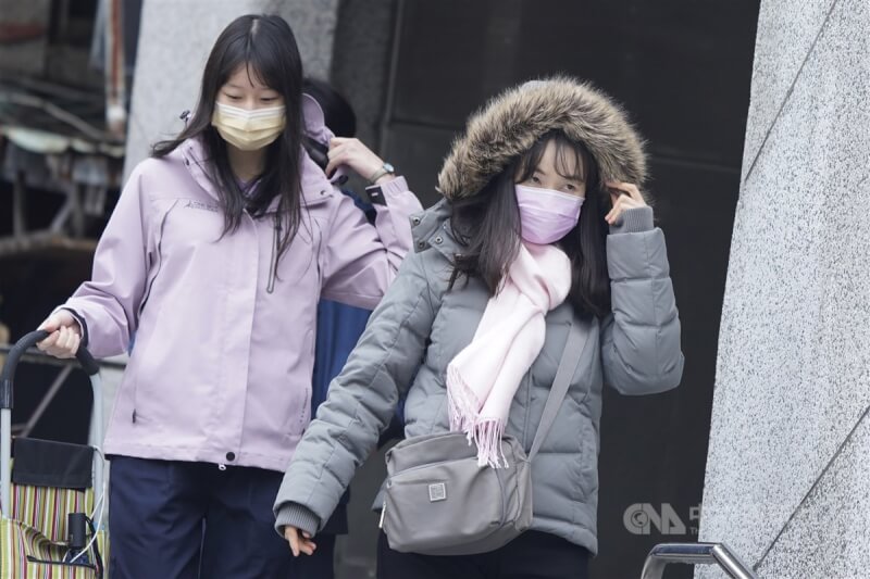 台北市民眾在雙連捷運站出口拉好外套禦寒。（中央社檔案照片）