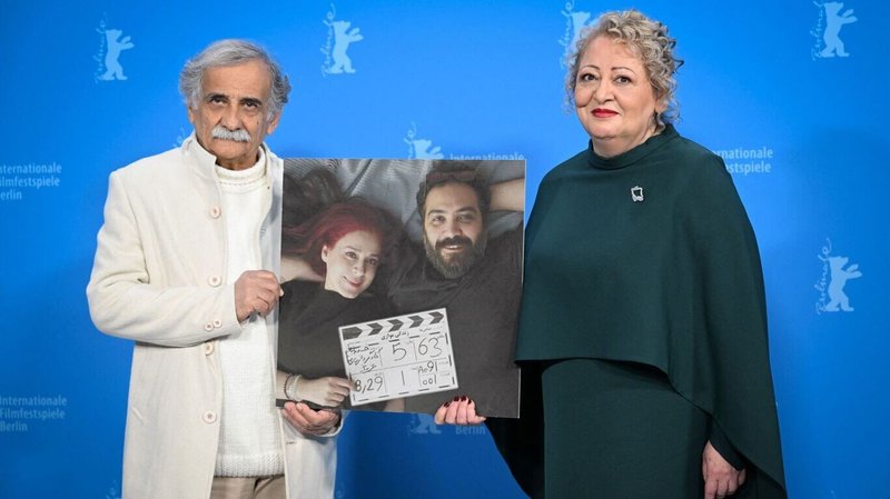 伊朗電影「我最喜歡的蛋糕」女主角莉莉法哈德普爾（Lili Farhadpour）（右）、男主角伊斯麥依梅赫拉比（Esmaeel Mehrabi）（左）共同出席柏林影展紅毯及記者會，兩人並隨身帶著夫妻檔導演的照片海報。（海鵬影業提供）中央社記者葉冠吟傳真  113年2月25日
