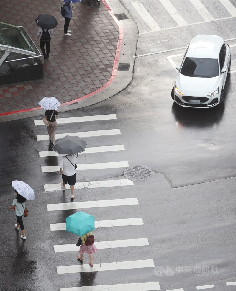 圖為台北市中山區一輛汽車轉彎時停等行人通過。（中央社檔案照片）