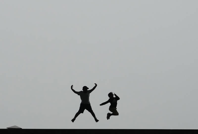 圖為韓國首爾的韓國國家博物館外孩童在空中跳躍。(美聯社)