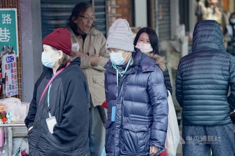 圖為台北市中山區民眾穿上保暖外套、戴帽子禦寒。（中央社檔案照片）