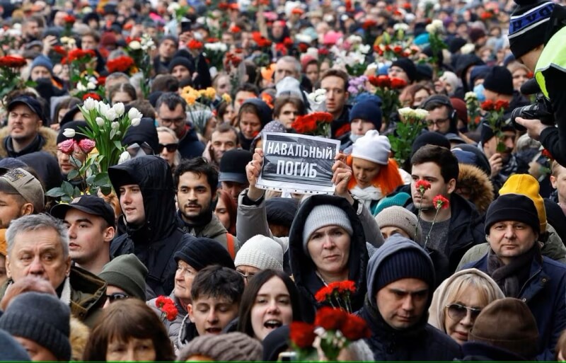 圖為1日民眾前往俄羅斯異議領袖納瓦尼的葬禮，有民眾高舉「納瓦尼去世了」標語。（路透社）
