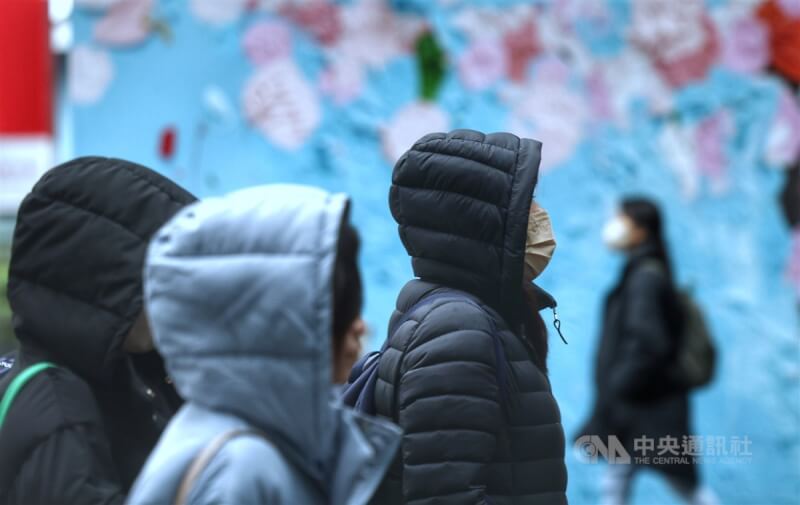 圖為台北市信義區街頭民眾穿外套、戴帽子禦寒。（中央社檔案照片）