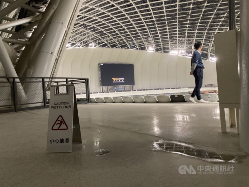 台北大巨蛋3日迎來第2場讀賣巨人交流賽,天花板漏水部分有明顯改善,積水的地板旁持續擺著「小心地滑」警告牌。中央社記者陳昱婷攝 113年3月3日