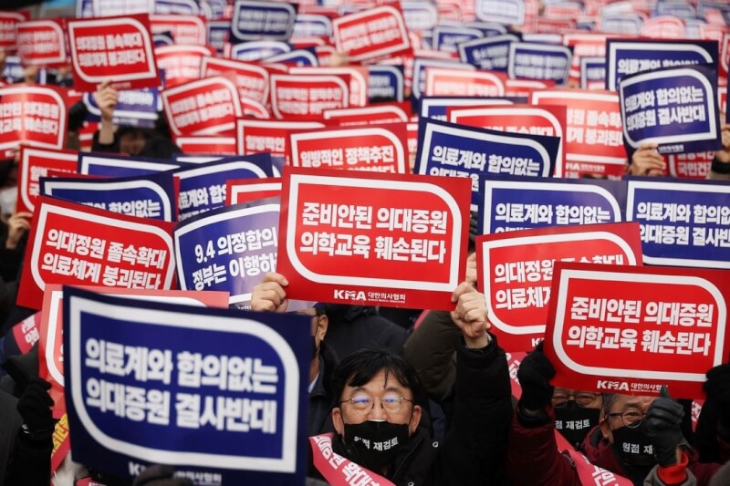 圖為韓國首爾，醫師高舉標語抗議醫學院擴招。（路透社）
