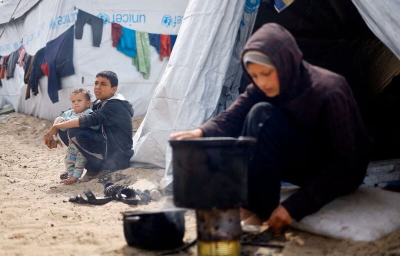 圖為巴勒斯坦兒童6日坐在加薩南部拉法市的帳篷營地。（路透社）