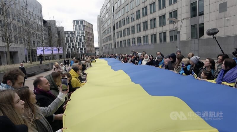 烏克蘭民眾2月24日在歐洲議會前廣場合力拉起30公尺長的國旗，並唱國歌、向俄烏戰爭下犧牲的國人致哀，在戰爭持續2年後提醒世人勿忘烏克蘭仍在苦難中。（中央社檔案照片）