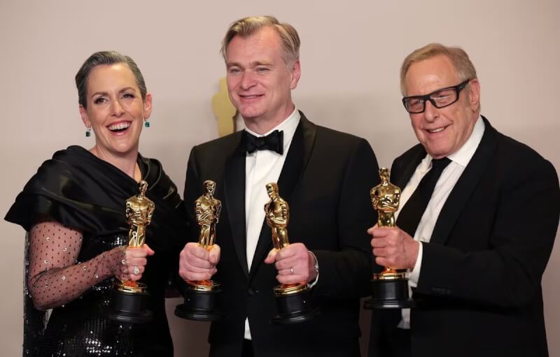 「奧本海默」10日在奧斯卡頒獎典禮，獲頒最高榮譽最佳影片獎。左起為製片艾瑪湯瑪斯、導演克里斯多福諾蘭、製片查爾斯羅文。（路透社）