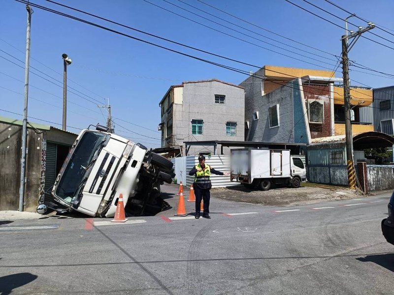 鍾姓男子12日駕駛一輛混凝土預拌車行經高雄市路竹區成功路，倒車時路面突然塌陷導致車輛陷入、動彈不得，駕駛自行爬出脫困，警方獲報到場協助引導交通。（高雄市政府警察局湖內分局提供）中央社記者張已亷傳真 113年3月12日