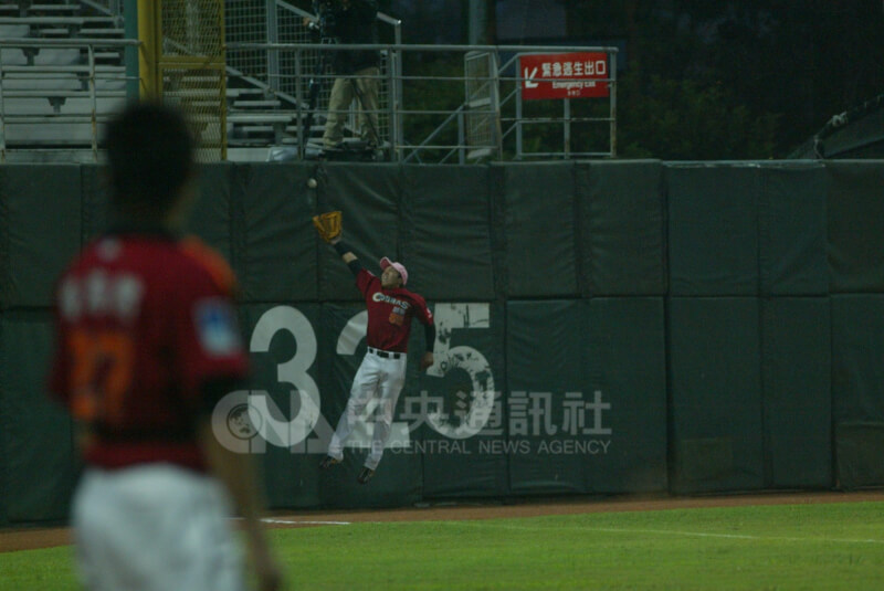 2007年诚泰左外野手周思齐（后）在全垒打墙前跳接。（中央社档案照片）