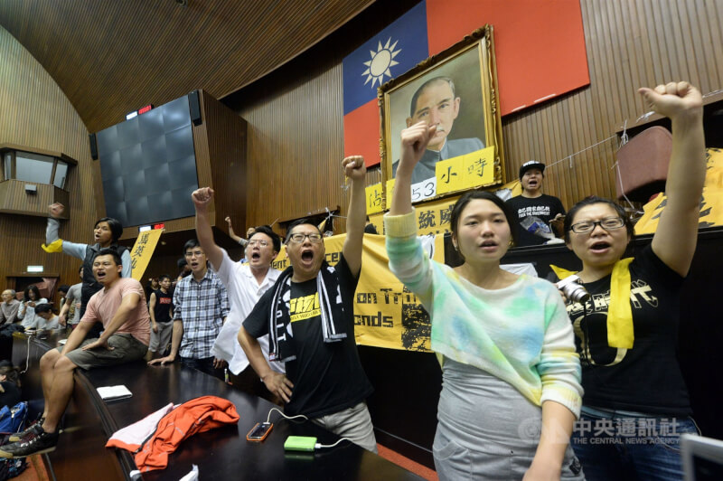 圖為2014年「318青年占領立法院」活動成員持續佔據議場，抗議民眾高喊口號表訴求，並對場內媒體叫囂，抗議負面報導。（中央社檔案照片）