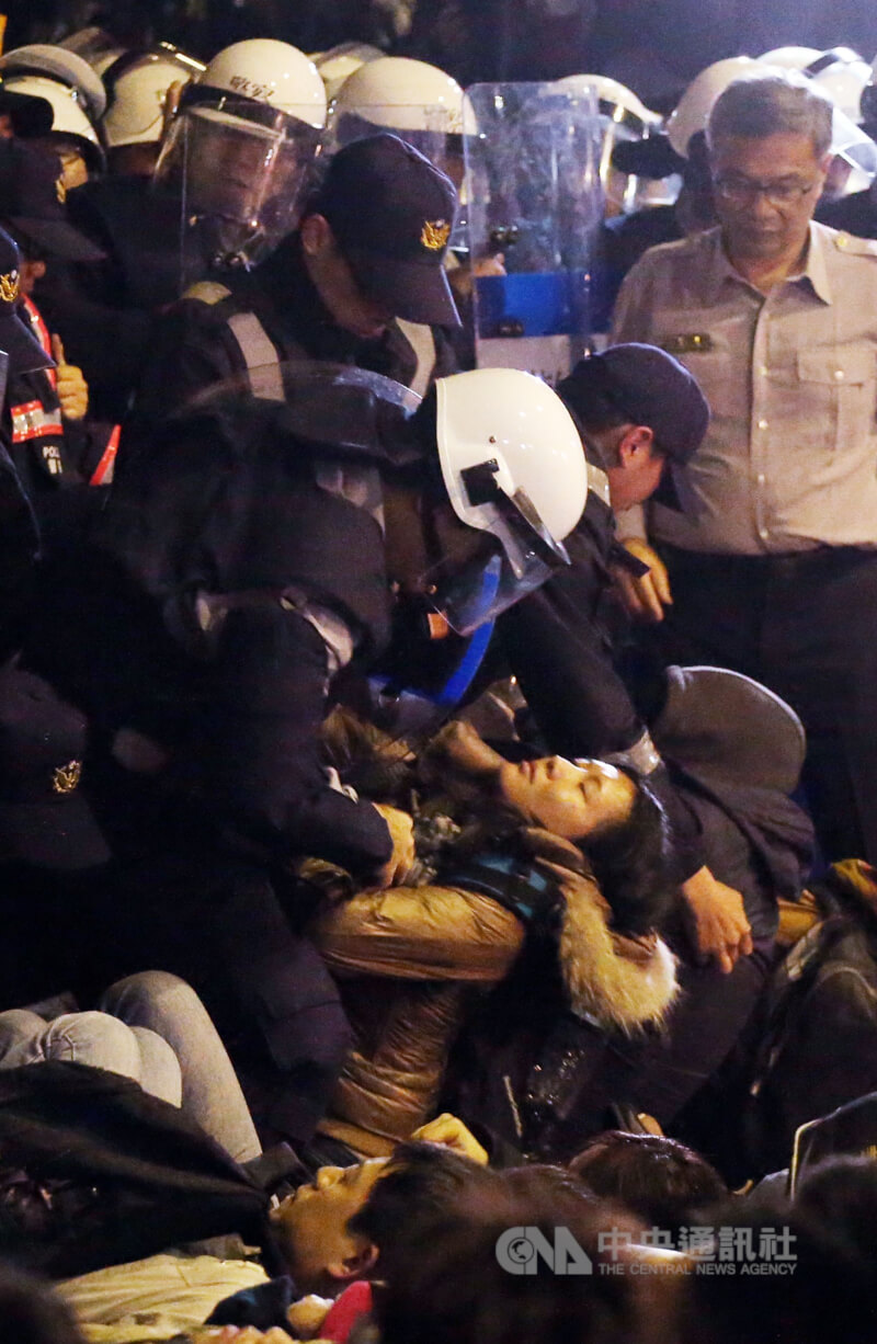 警方在行政院内徒手搬离抗议群众，一名女子遭抬起。（中央社档案照片）