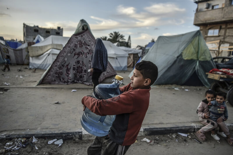 加薩物資嚴重不足，9日拉法市一名兒童緊抱著水瓶。（安納杜魯新聞社）