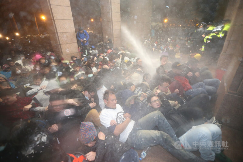 反服贸民众冲入行政院占据广场与部分建筑，凌晨4时30分，警方以水柱驱离民众。（中央社档案照片）