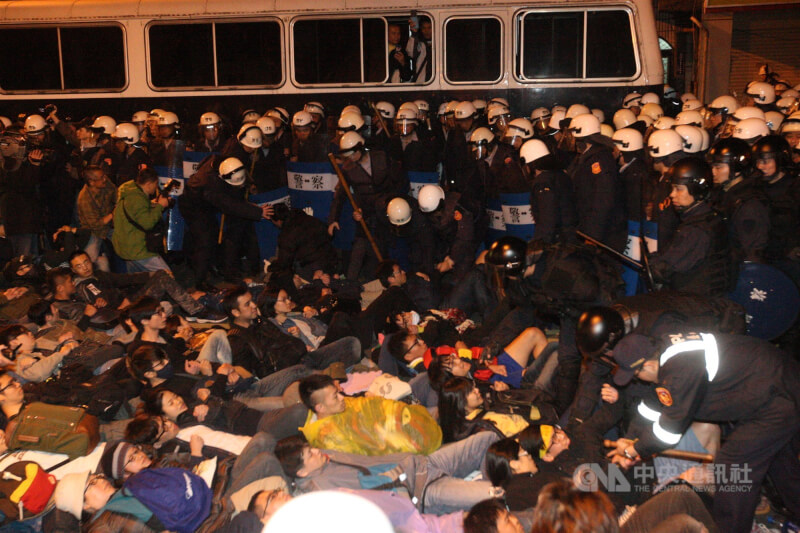 反服贸群众闯入行政院，警方24日凌晨集结部署清场，部分民众牵手躺在地上抵抗。（中央社档案照片）