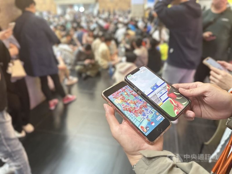 人氣手遊Pokémon GO推出團體戰日活動,其中「原始固拉多團體戰日」23日下午登場,台北車站1樓大廳有百餘名玩家聚集,眾人或坐或站、專注抓寶。中央社記者劉建邦攝 113年3月23日