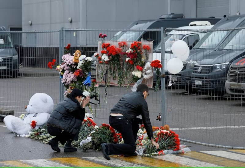 莫斯科近郊一座音樂廳遭遇恐怖攻擊，23日民眾在臨時紀念碑前獻花悼念罹難者。（路透社）