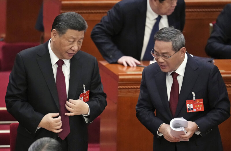 中國國家主席習近平（左）和中國總理李強（右）在今年全國人大會議上交談。（共同社）