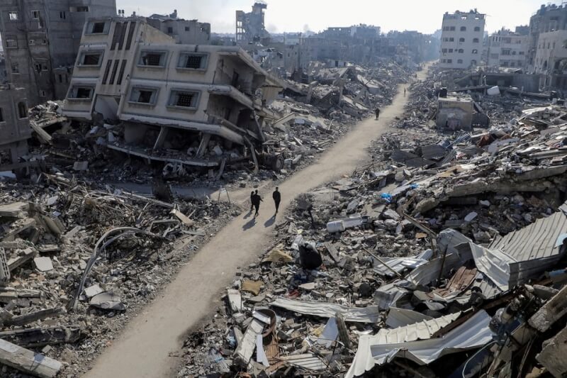 圖為加薩北部地區建物被摧毀，巴勒斯坦民眾走在路上。（路透社）