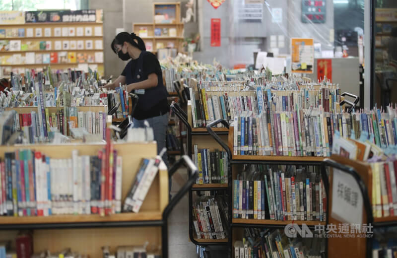 台北市立圖書館臨時櫃台後方書架滿滿都是民眾預約待取書籍。（中央社檔案照片）