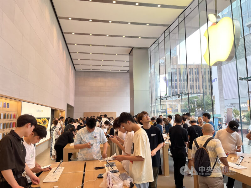 圖為中國消費者在上海市南京東路蘋果零售店內試用手機畫面。（中央社檔案照片）