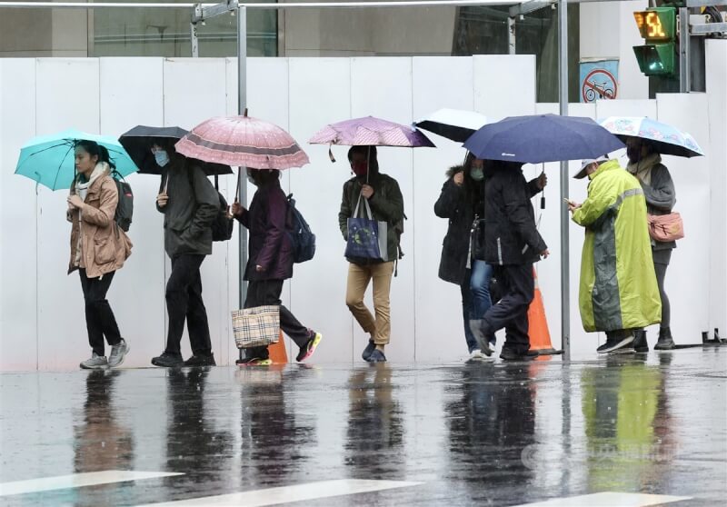 圖為台北市中正區外出民眾撐傘遮擋雨勢。（中央社檔案照片）