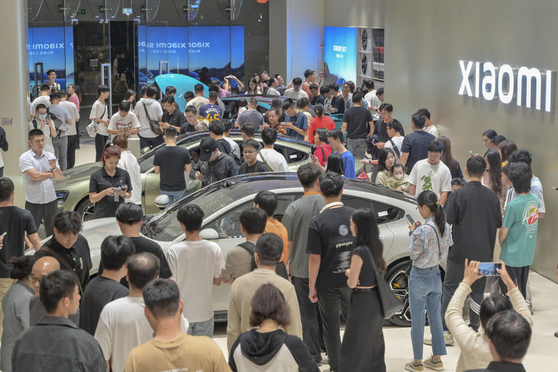 圖為28日晚間廣州市一間小米門市不少民眾參觀小米SU7純電轎車。（中新社）