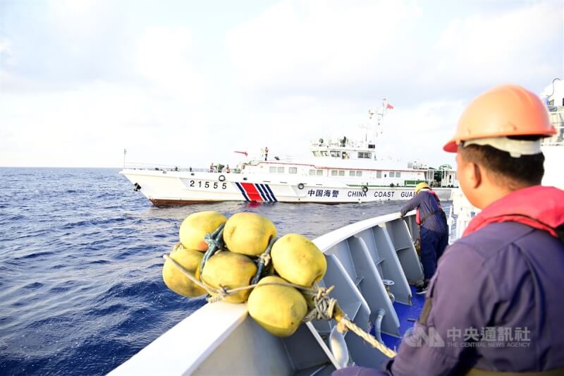 菲律賓海巡艇上的海岸防衛隊人員23日身穿救生衣，手持數串黃色防撞泡棉浮球，在船頭及船尾準備好在與中國海警和民兵船碰撞時，以泡棉浮球減輕撞擊力。中央社特約記者Edward Bungubung攝 113年3月29日