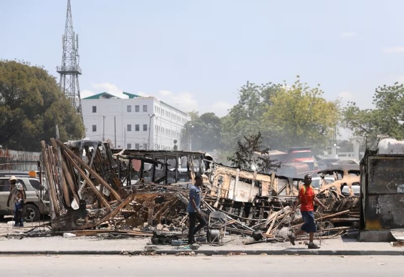 圖為海地首都太子港民眾經過幫派破壞的街道。（路透社）
