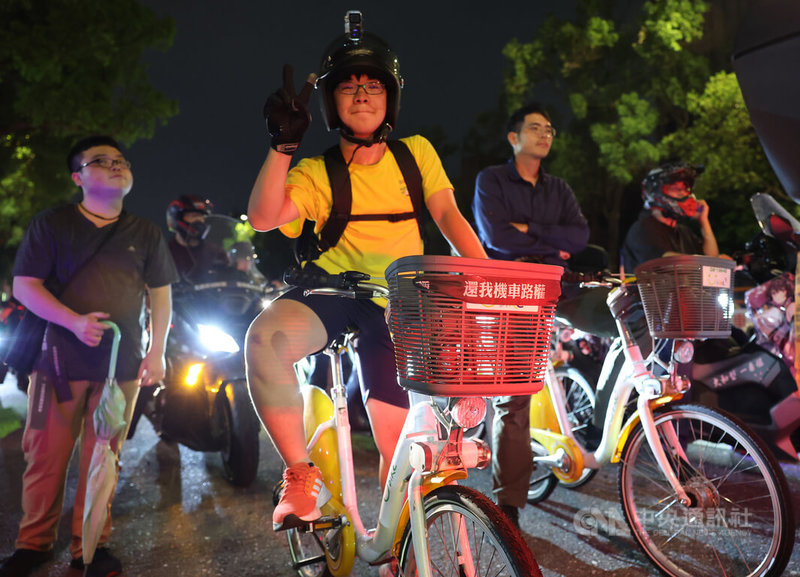 台灣機車路權促進會30日晚間在台北發起「路邊臨停不放任,禁行惡法應廢除」機車遊行活動,與會者在立法院群賢樓前集結,現場也有人騎乘自行車參與。中央社記者趙世勳攝 113年3月30日