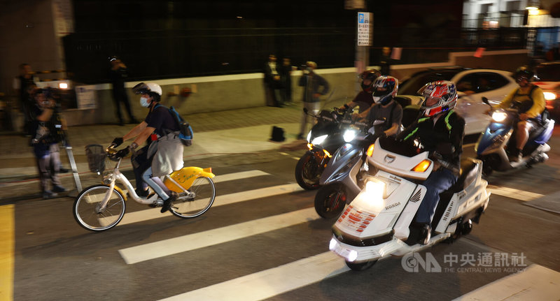 台灣機車路權促進會30日晚間在立法院外舉辦「路邊臨停不放任,禁行惡法應廢」遊行,號召機車騎士騎車到場響應參與,共同呼籲政府解禁機車路權。中央社記者趙世勳攝 113年3月30日