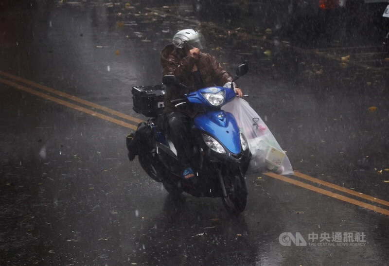 台北市松山區下午突然下起大雨,騎士來不及換穿雨衣,只能冒雨前進。中央社記者裴禛攝 113年3月31日