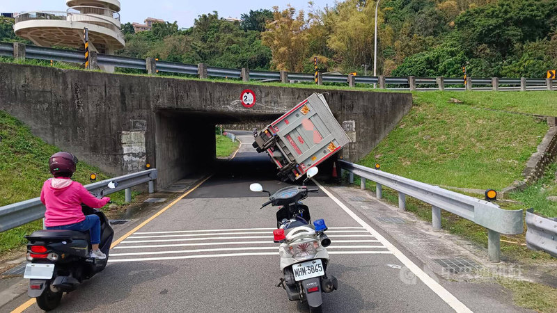 黃姓男子1日下午駕駛大貨車行經新北市淡水區關渡橋下時，疑因疲勞駕駛誤闖機車道，且未注意限高，導致車斗卡在涵洞前，警方已聯繫拖吊業者到場排除。（翻攝照片）中央社記者高華謙新北傳真  113年4月1日