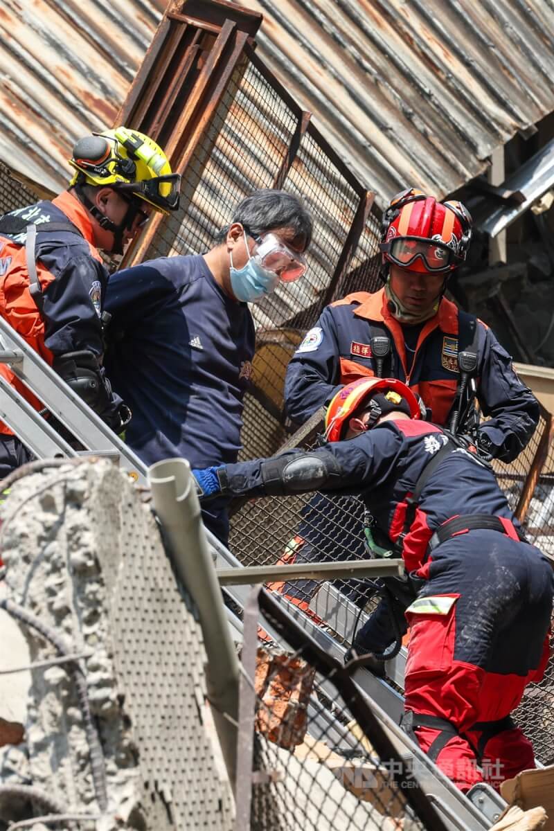 花蓮近海強震全台有感，新北市中和區一處建物後棟倉庫3日倒塌，現場一度有民眾受困，消防局獲報動員搜救，成功救出受困者（左2）。中央社記者吳家昇攝 113年4月3日