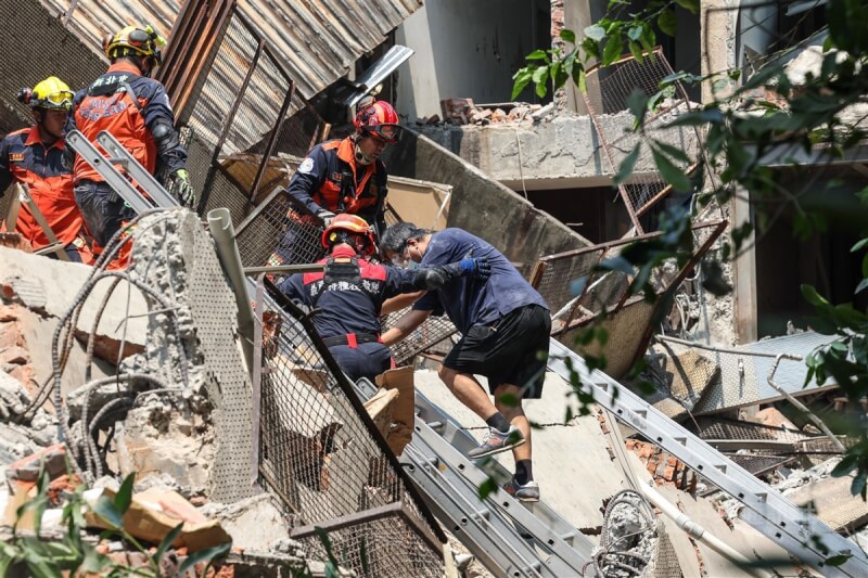 新北市中和區一處建物後棟倉庫3日上午因地震倒塌，內部受困者在消防局搜救人員馳援下順利脫困，緩步爬下樓梯。中央社記者吳家昇攝 113年4月3日