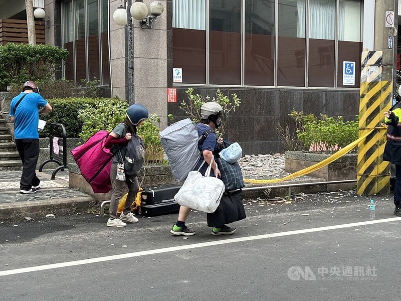 花蓮近海地震導致吉安山海觀大樓遭列危樓,許多住戶5日上午頭戴安全帽,返家取出必要家電跟貴重物品等,每個人都大包小包。中央社記者盧太城攝 113年4月5日